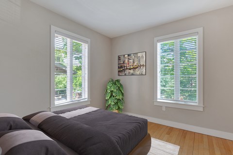 a bedroom with a bed and two windows