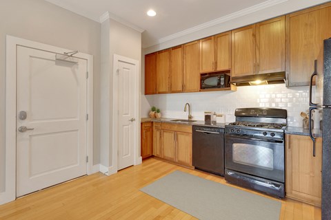 a kitchen with wooden cabinets and stainless steel appliances and a white door
