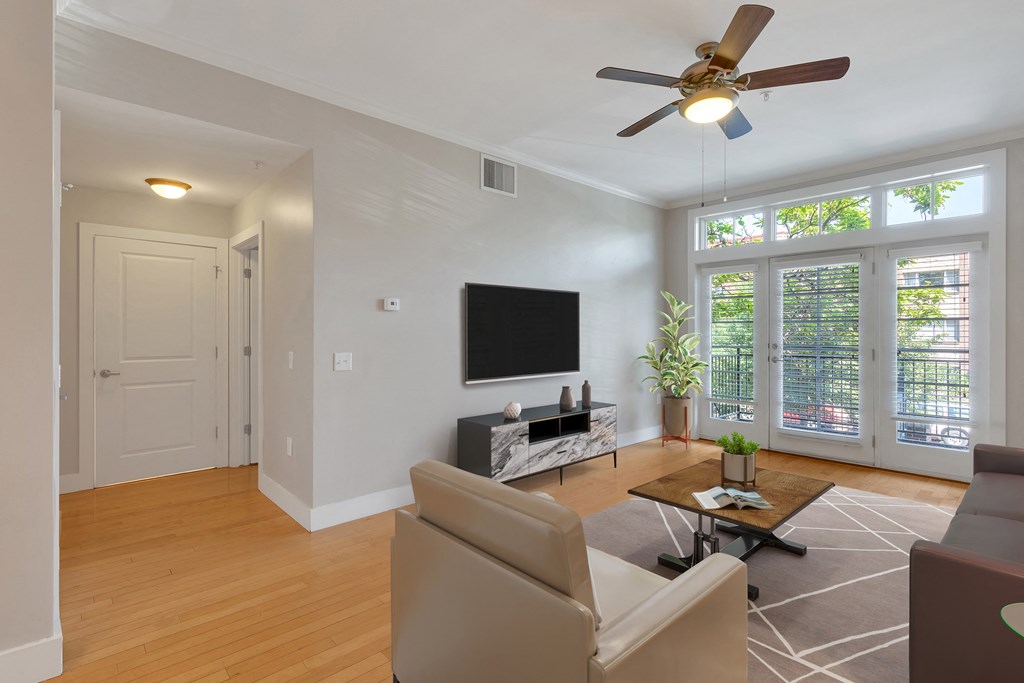 a living room with a ceiling fan and a television