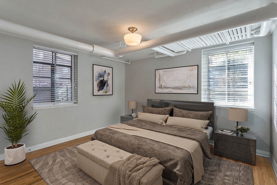 a bedroom with a bed and two windows