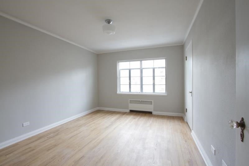 an empty room with white walls and a window