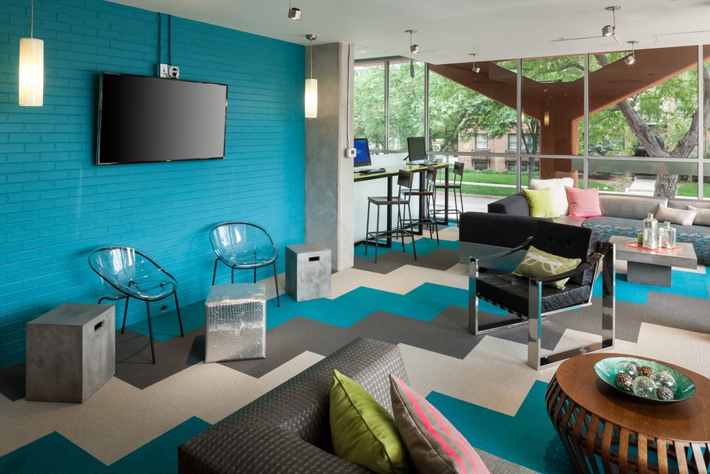 a living room with a blue brick wall and a television