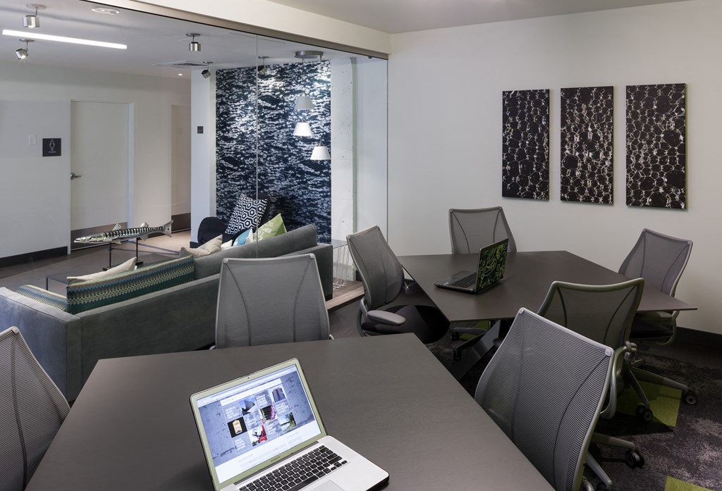 a laptop computer sitting on a table in a room with chairs