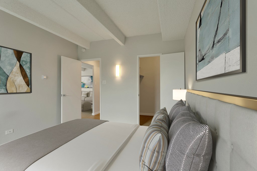 A bedroom with a bed and a painting on the wall.