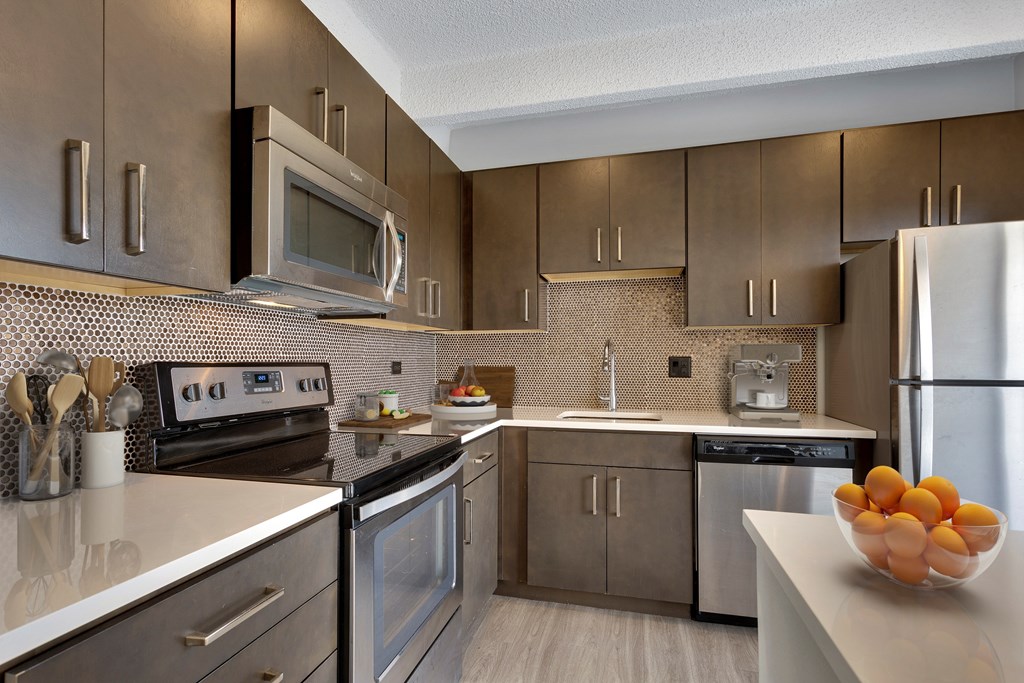 A modern kitchen with stainless steel appliances and wooden cabinets.