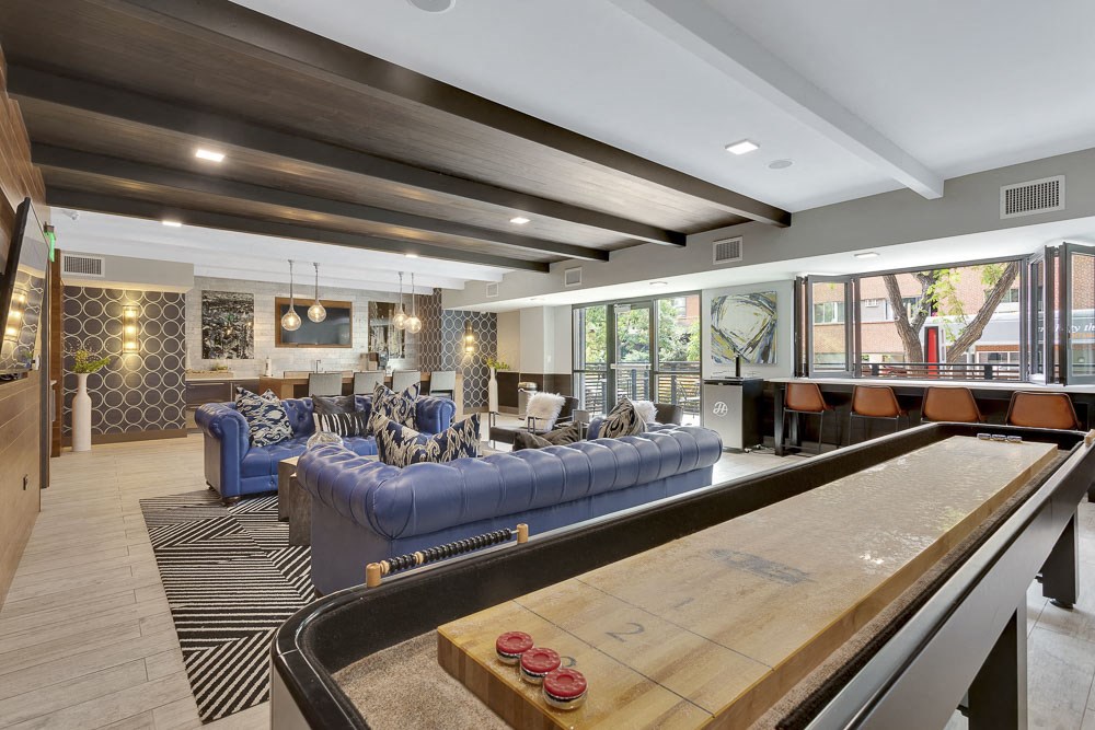 a living room with a shuffleboard table and couches