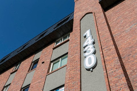 a brick building with a neon sign on the side of it