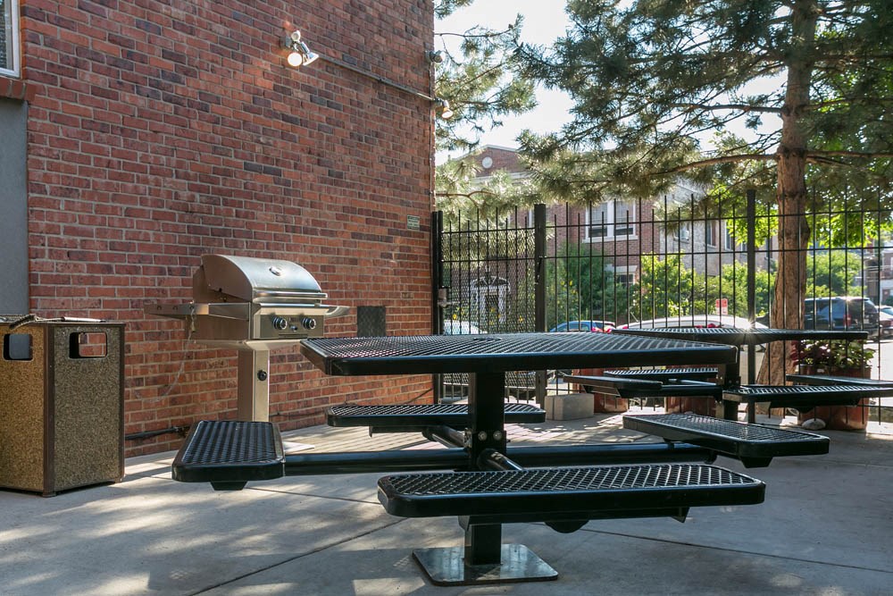 a group of picnic tables in front of a brick building