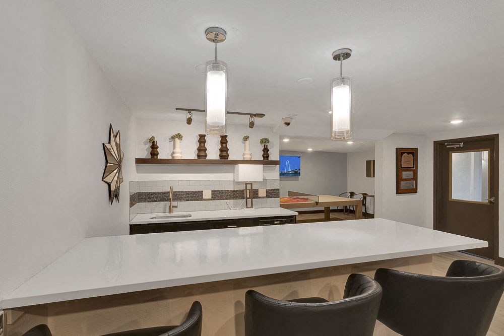 a kitchen with a white counter top and chairs