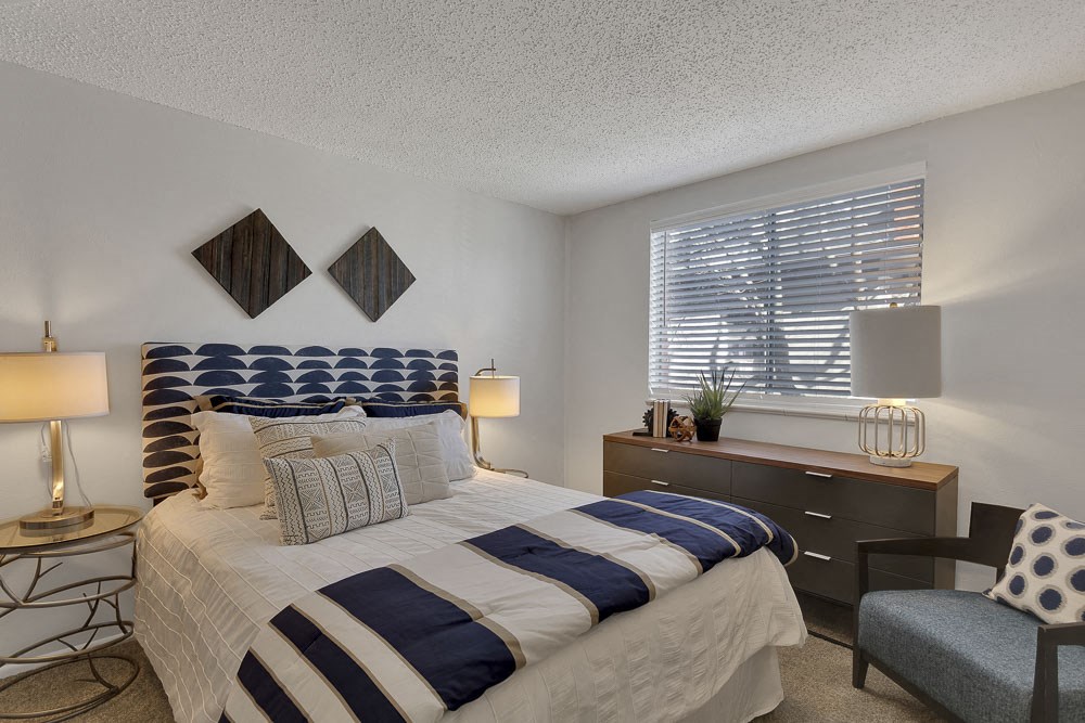 a bedroom with a bed and a dresser and a window