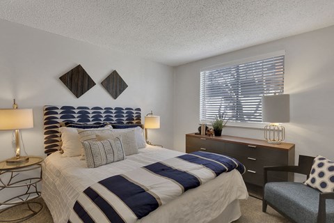 a bedroom with a bed and a dresser and a window