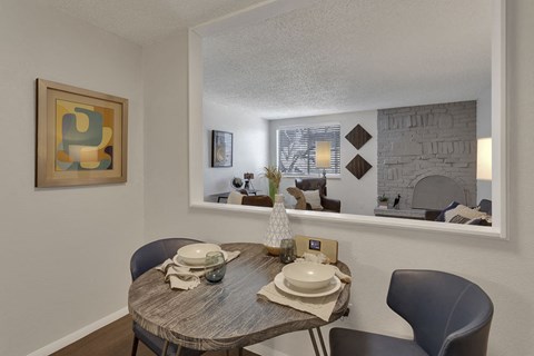 a dining room with a table and chairs next to a window