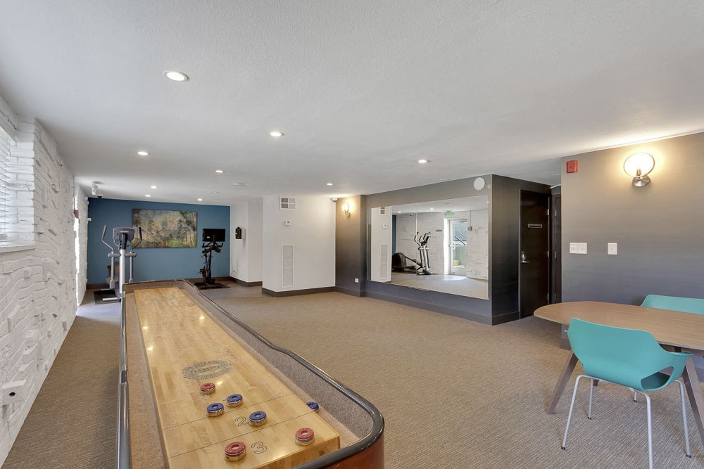 a game room with a shuffleboard table