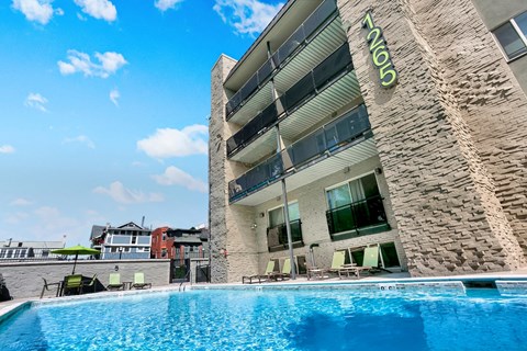 A swimming pool in front of a building with the number 1105 on it.