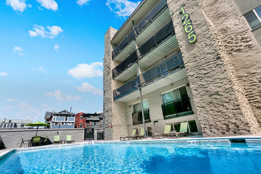 A swimming pool in front of a building with the number 1105 on it.