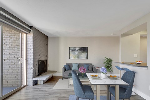 A dining room with a table set for two and a fireplace.
