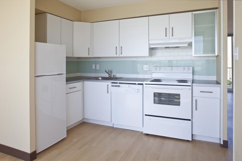 a white kitchen with white appliances and white cabinets
