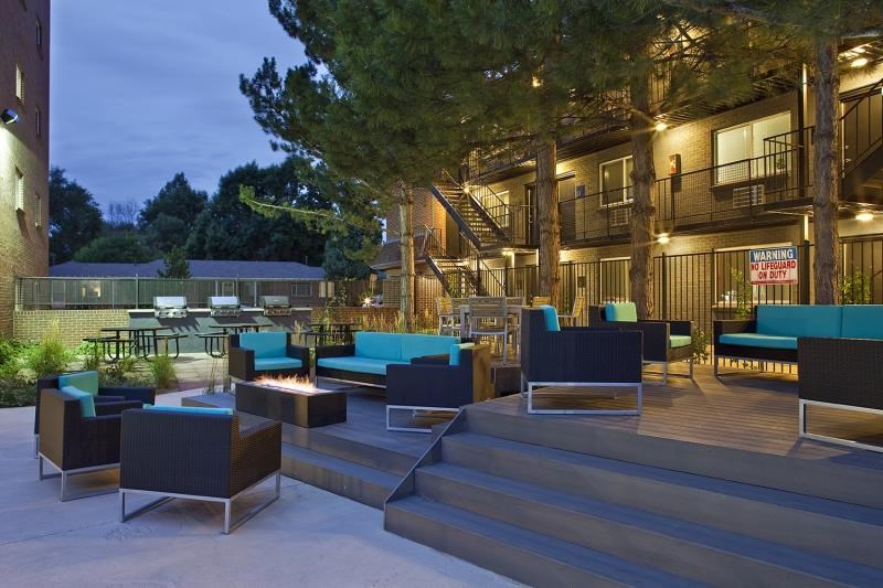 a patio with chairs and tables and a fire pit