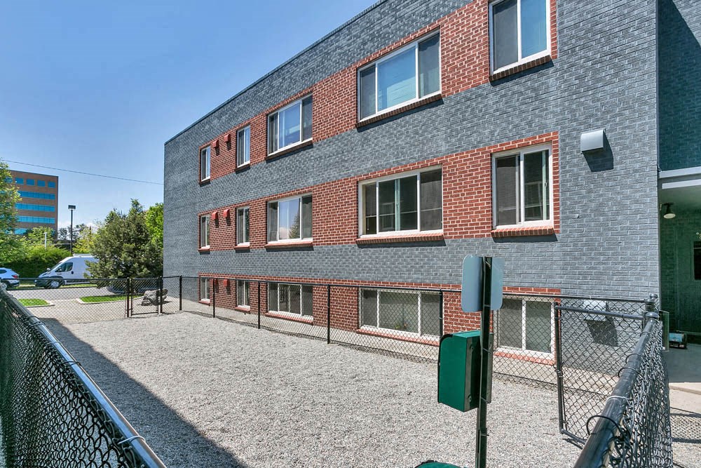 a brick building with a chain link fence in front of it