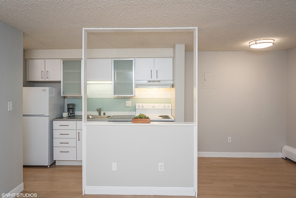 an open kitchen with white cabinets and a white refrigerator