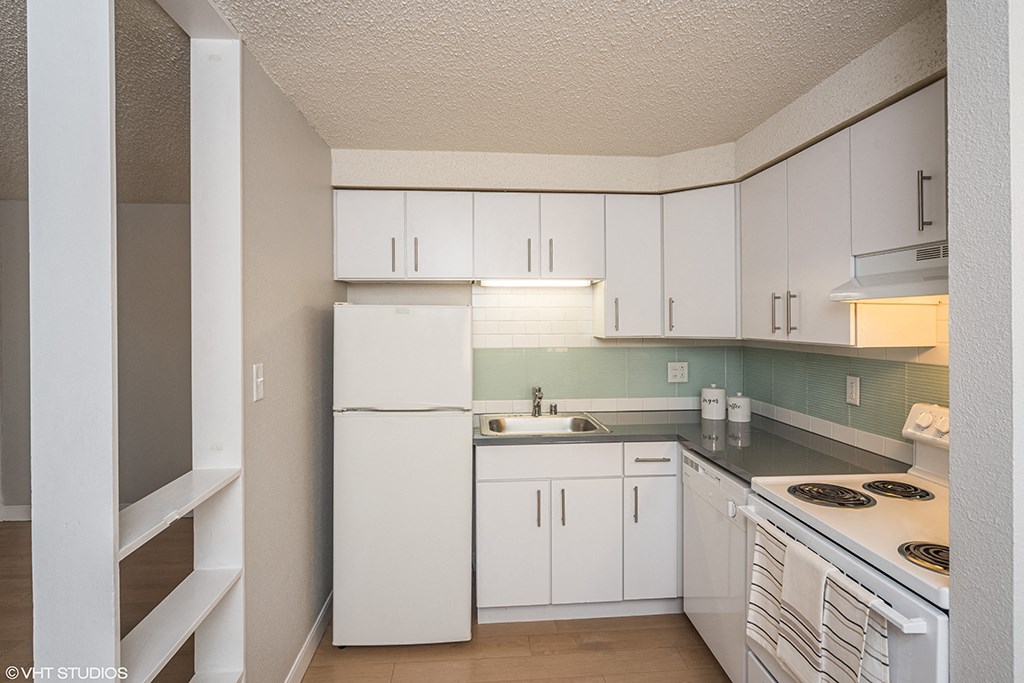a kitchen with white cabinets and a stove and a refrigerator