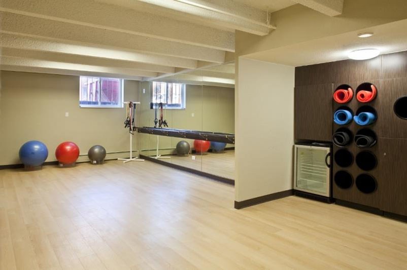 a fitness room with weights and a mirror