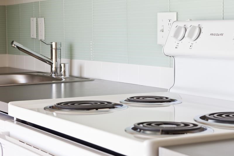 a white stove top oven sitting next to a sink