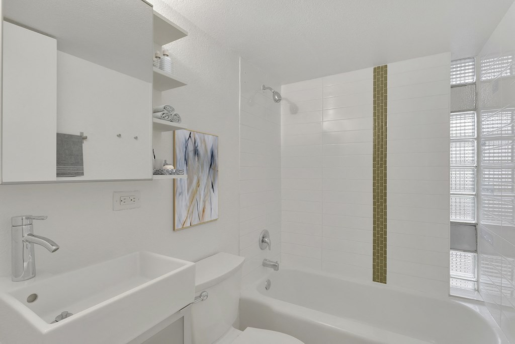 a white bathroom with a tub and a sink and a toilet