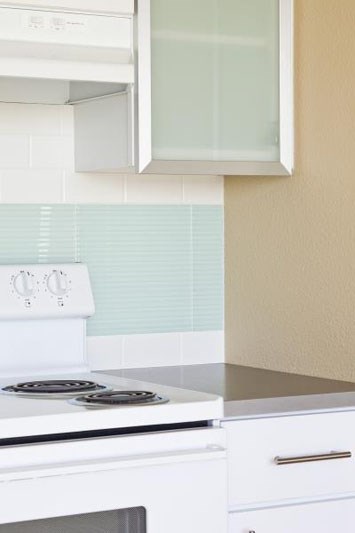 a white kitchen with a stove and a microwave