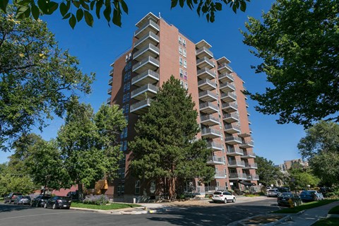 a building on the corner of a street with trees