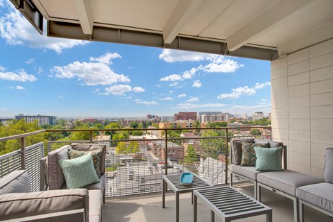 A balcony with a view of the cityscape and a clear blue sky.