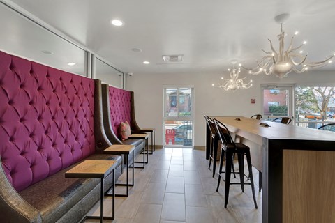 A long row of bar stools are lined up in front of a counter.