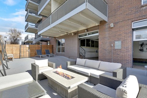 A modern outdoor seating area with a fire pit in the center.