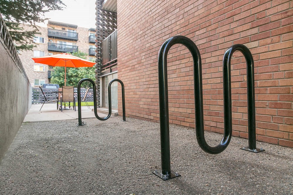 a group of bike racks in front of a brick wall