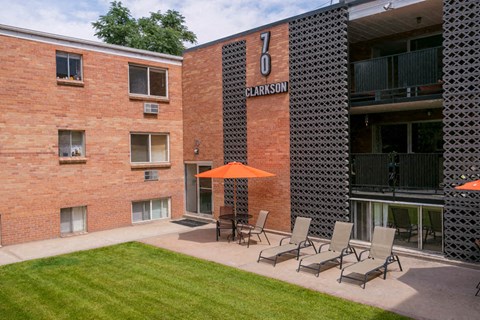 a patio with chairs and an umbrella outside of a building