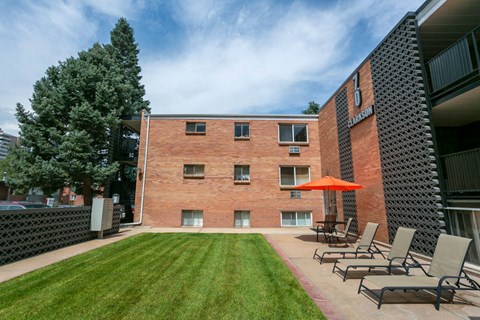 our apartments have a large patio with chairs and an umbrella
