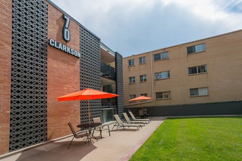 a courtyard with tables and umbrellas in front of a building