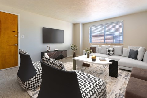 A living room with a black and white patterned chair.