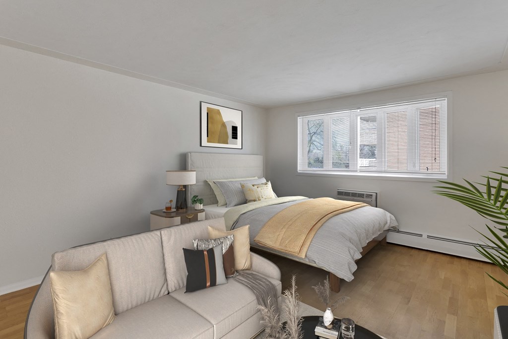 the living room of a bedroom with a bed and a couch