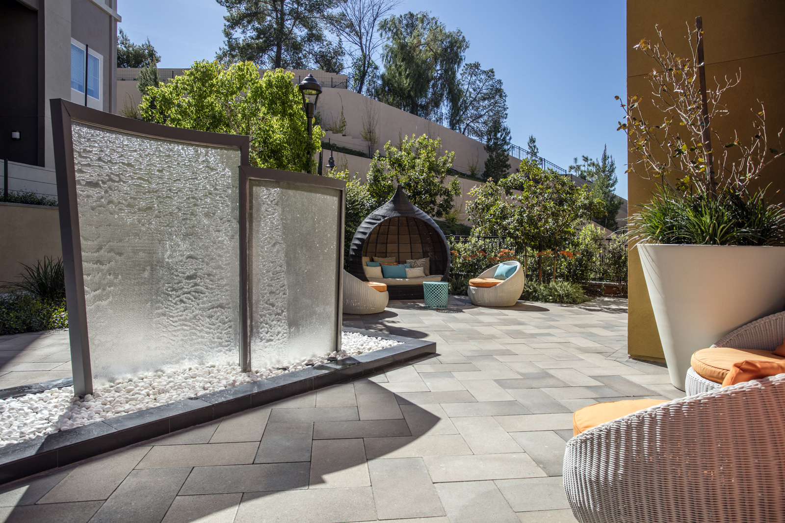 a courtyard with a water fountain and chairs