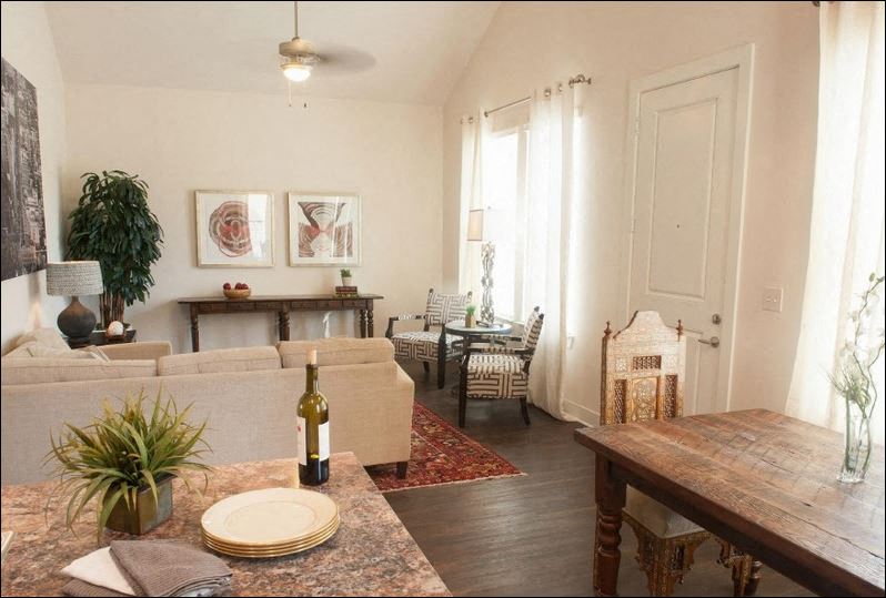 a living room with a couch and a table with a bottle of wine