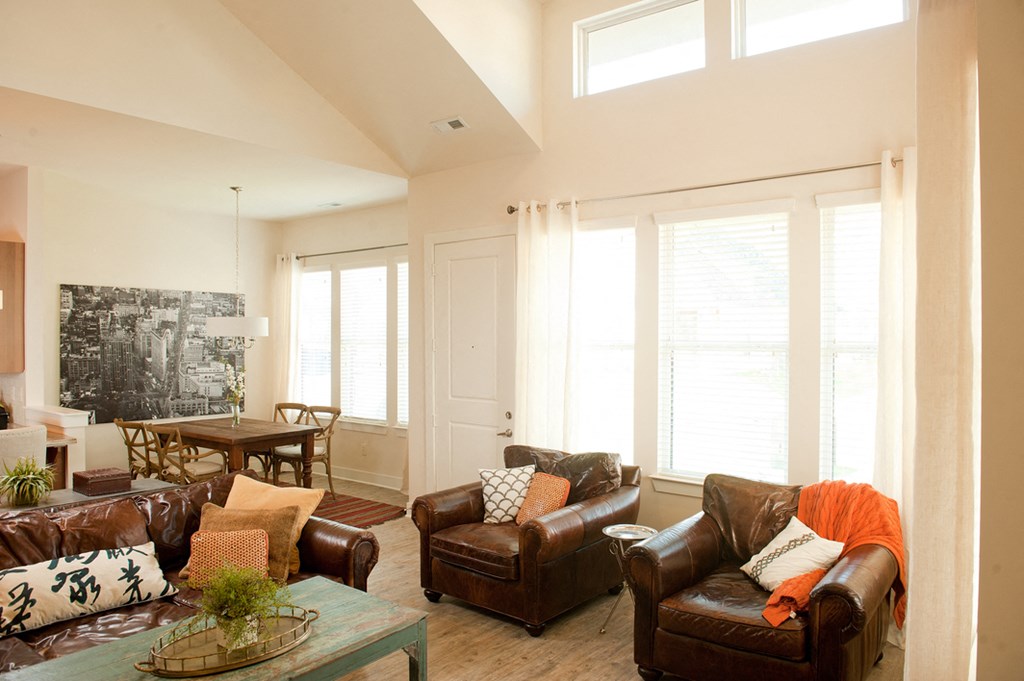 a living room with leather furniture and large windows