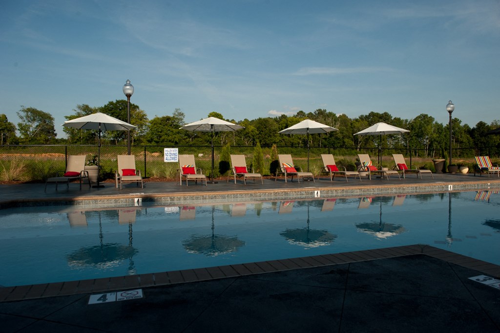 a swimming pool with umbrellas and chairs around it