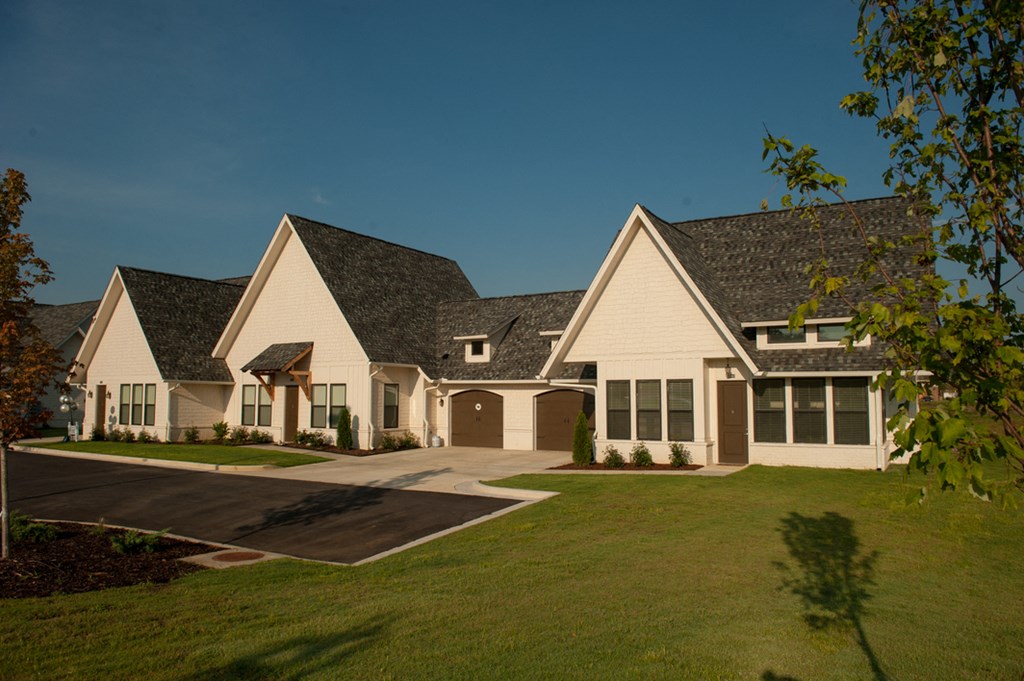 a house with white siding and a green lawn and a driveway