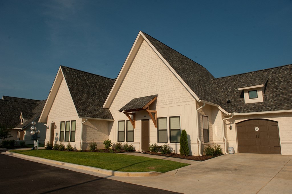 a white house with gray roofs and a driveway