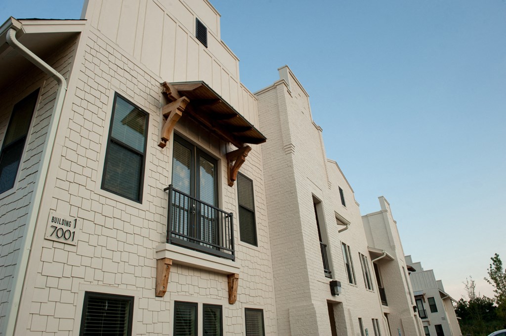 a white building with a balcony and a blue sky