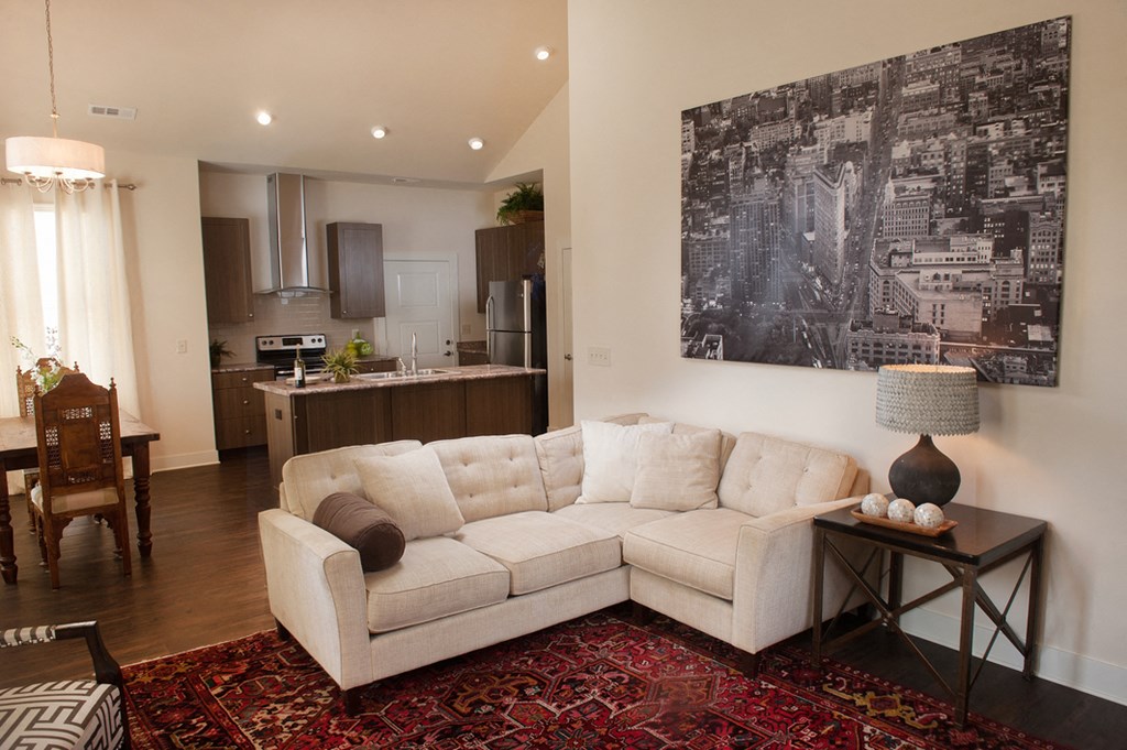a living room with a couch in front of a kitchen