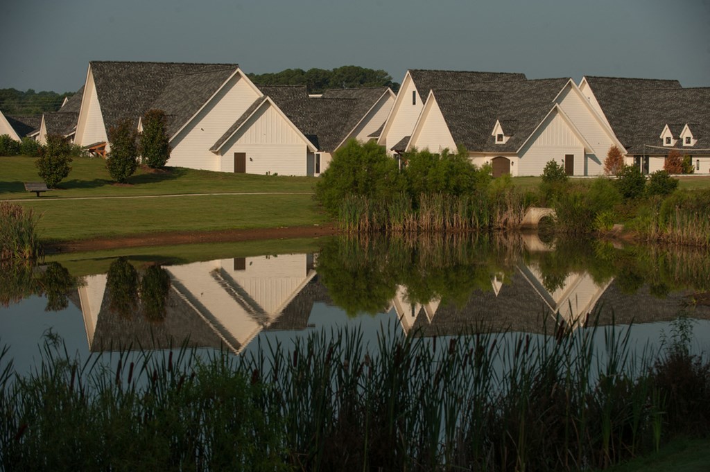 a group of houses reflected in a pond