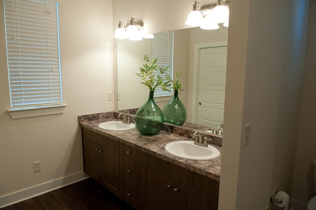 an empty bathroom with two sinks and a mirror