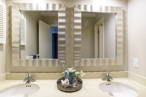 two sinks in a bathroom with two mirrors